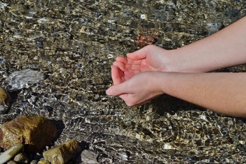 Beautiful woman hands on water