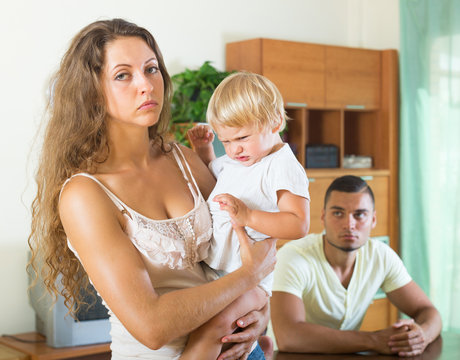 Young family of three with baby having quarrel