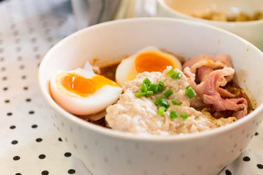 Thai noodle with pork and boiled egg on table