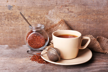 Cup of tasty rooibos tea, on wooden table