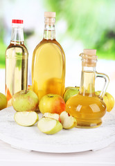 Apple cider vinegar in glass bottles and ripe fresh apples,