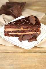 Chocolate cake on plate, on wooden background