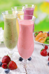 Delicious berry cocktails on table on bright background