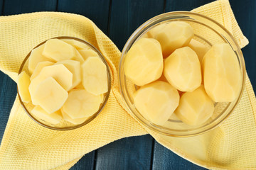 Raw peeled and sliced potatoes in glass bowls