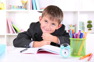 Schoolboy sitting at table in classroom