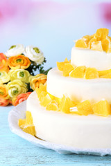 Beautiful wedding cake with oranges on  light background