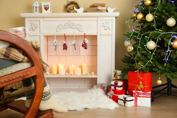 Woman holding cup of hot drink in front of fireplace
