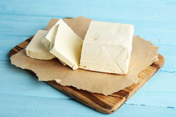 Fresh butter on cutting board, on color wooden background