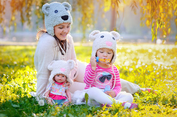 mother and daughter in knitted hats Bears, with soap bubbles