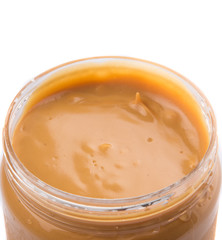 Peanut butter in a jar over white background