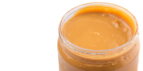 Peanut butter in a jar over white background