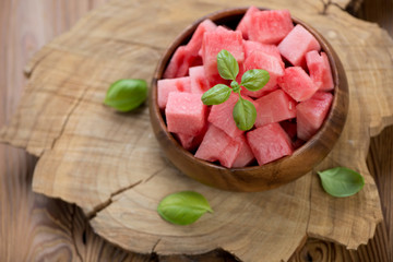 Watermelon cubes over rustic wooden background, above view
