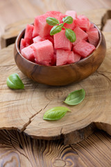Watermelon sliced into cubes and served in a wooden bowl