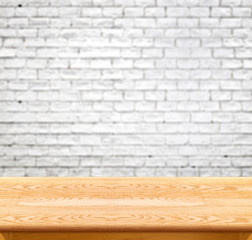 Empty wood table and white brick wall in background. product dis