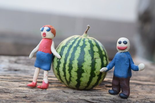 Plasticine man and woman near a watermelon