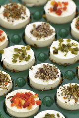 Cheese appetizers decorated with spices on green