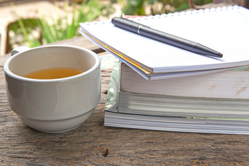 Books, note, tea on wooden background
