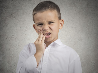 Headshot child with toothache isolated on grey wall background 