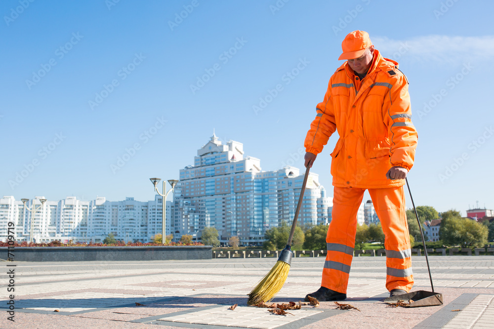 Wall mural man road sweeper caretaker cleaning city street with broom tool