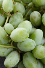 ripe green grapes on black wood table