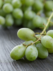 ripe green grapes on black wood table