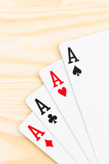 Four aces on wooden background