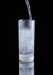 pouring cold water in simple highball glass
