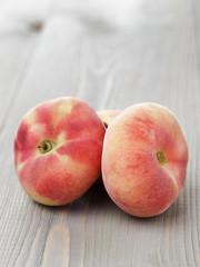 flat peaches on wood table