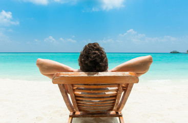 Man relaxing on beach - obrazy, fototapety, plakaty