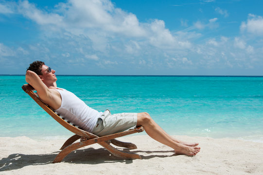 Man sunbathing on the beach near the ocean