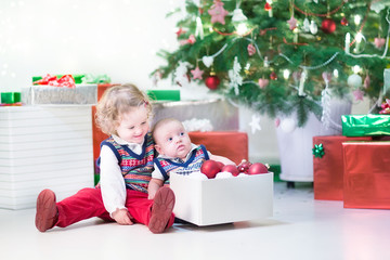 Fototapeta na wymiar Little kids helping to decorate Christmas tree
