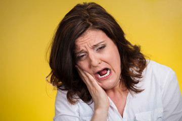 woman with sensitive tooth ache isolated on yellow background 