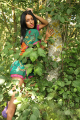 Obraz na płótnie Canvas girl posing on a background of green trees