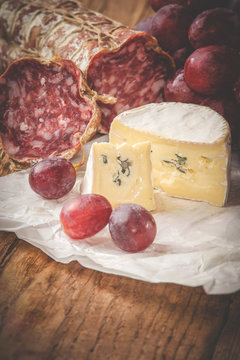 Blue cheese with salami on a wooden rustic table