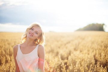 Fototapeta na wymiar Beautiful blond girl at the wheat field