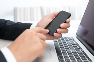 businessman sitting at a laptop with phone