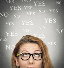 uncertain woman looking up, background with yes no choices