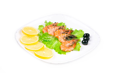 Boiled shrimps with olives and sliced lemon.