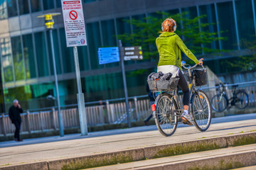 A young woman with ginger hair cycling in the street