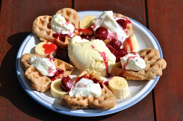 Waffeln mit heißen Kirschen, Eis und Sahne