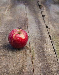 ripe red apple on wooden background vertical