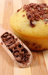 Fresh baked muffin and grated chocolate on wooden spoon