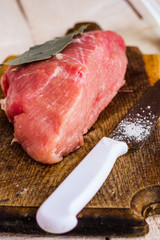raw meat on a cutting board with spices, knife