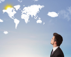 Businessman looking at world clouds and sun on blue sky