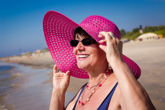 Happy mature woman on the beach. Selective focus.