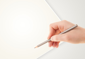 Human hand drawing with pencil on empty paper template
