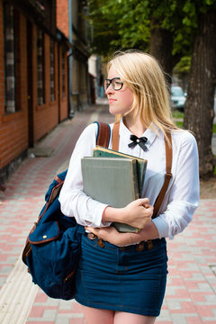Blond school girl with nerd glasses. Selective focus.
