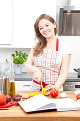 frau in der küche schneidet gemüsse 