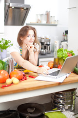 Frau mit laptop in der küche 