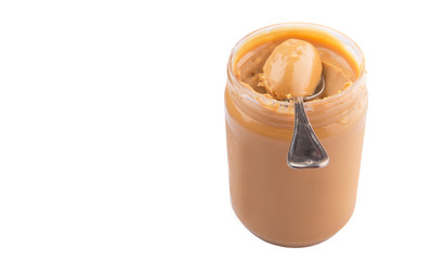 An opened jar of peanut butter with a small spoon